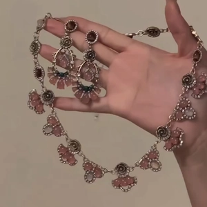 Pink resin flower necklace and earring set with crystals on elegant model