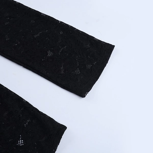 Detailed close-up of intricate black floral lace pattern with hollow-out texture