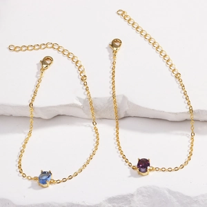 Detailed shot of gold-plated bracelets featuring oval blue and purple zircon stones