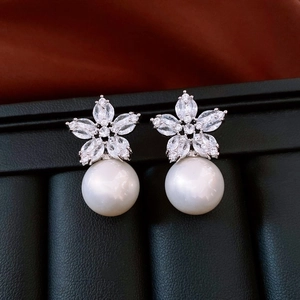 Close-up of 18K gold-plated floral pearl earrings with shimmering cubic zirconia accents