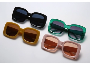 Detail of oversized square sunglasses in black, green, yellow, and pink colors