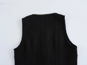 Dettaglio dello scollo rotondo e del taglio senza maniche su tessuto per abiti in tweed nero