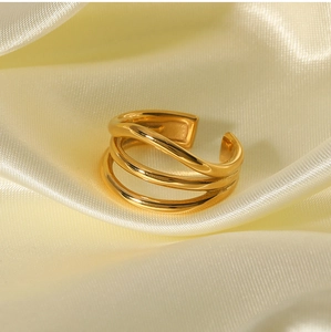 Detail shot of multi-layer 18K gold-plated open ring on soft yellow silk fabric