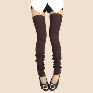 Detailed knit texture of thick chocolate brown over-knee leg warmers on a model