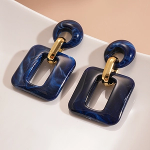Detail of dark blue marble resin square pendant with golden metal ring buckle on ceramic