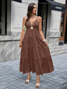 Details des eleganten braunen Maxikleids mit tiefem V-Ausschnitt und offenem Rückendesign