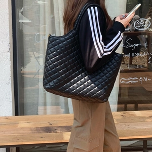 Chic black quilted tote bag with large capacity for women shown in a street style street view