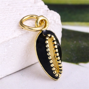 Macro detail of black and gold shell pendant with golden bead accents on stone