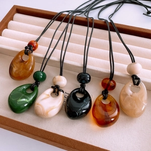 Detailed close-up of colorful teardrop acrylic pendants on a professional jewelry tray