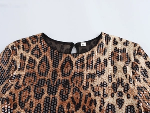 Gros plan de sequins léopard scintillants et étiquette de taille S sur l'encolure