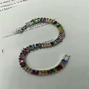 Detail shot of colorful rectangular crystal tennis bracelet on a white book page