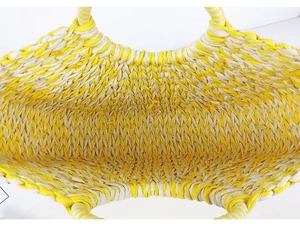 Top-down detail view of woven straw beach bag showing yellow and beige rope texture