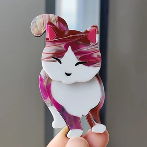 Detail shot of the acrylic calico cat brooch showing the purple and pink fluid art texture