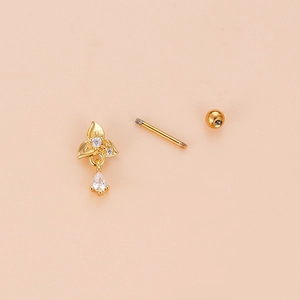 Golden flower earring with teardrop zircon and screw ball back on beige background