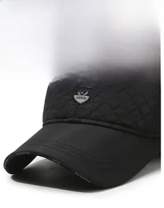 Detail of black quilted baseball cap with shield logo and Fashion text on the brim