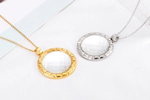 Detail view of gold and silver gear-shaped necklaces with large faceted crystals
