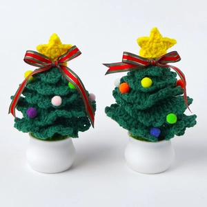 Close-up of handmade crochet Christmas trees with colorful pompoms and star toppers