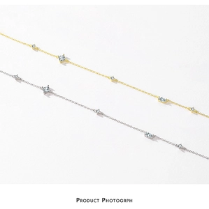 Detailed view of silver and gold plated necklaces with cubic zirconia pendants on white background