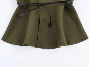 Detail of dark olive green knit fabric texture with black drawstring and metal tips