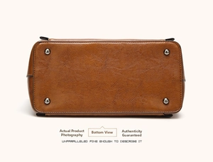 Detailed view of the brown leather bag base with four protective metal stud feet