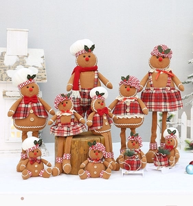 Close-up of plush gingerbread doll ornaments with red plaid outfits and festive details