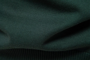 Vue macro du tricot de coton vert foncé montrant la texture douce et le tissage fin