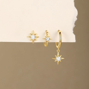 Three-piece gold S925 silver star earring set with white zircons on beige paper