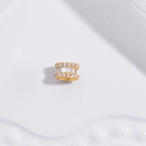 Nahaufnahme der goldenen Zylinderperle mit Zirkonia-Reihen und rechteckigen Kristallen
