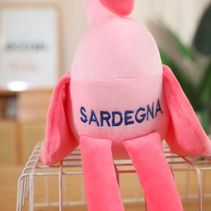 Close-up of plush flamingo with SARDEGNA embroidery on soft pink fabric detail