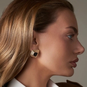 Luxuriöse 18k vergoldete Edelstahl Ohrringe mit schwarzem Achat an einem Modell