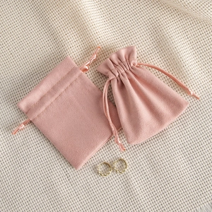 Pink velvet drawstring jewelry pouch with elegant gold and pearl earrings set