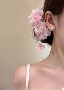 Pink fabric flower hair clip with long tassel and water drop pearls on a female model