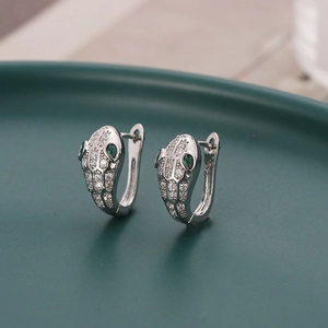 Silver snake-shaped hoop earrings with green gemstone eyes and white cubic zirconia