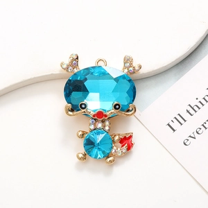 Macro detail of sky blue crystal dragon charm with gold plating and colorful rhinestones