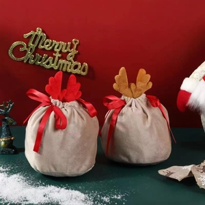 Close-up of velvet reindeer candy bags with cute antlers on a festive Christmas snow background