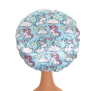 Close-up of kids satin bonnet featuring colorful unicorn, rainbow and cloud patterns