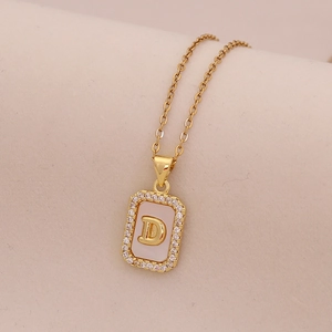 Détail du collier en or 18 carats avec pendentif lettre D et incrustation nacre