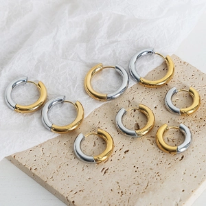 Minimalist gold and silver two-tone hoop earrings in various sizes on stone base