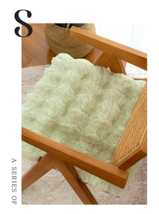 Cuscino per sedia in peluche verde salvia su una sedia in legno con schienale in rattan
