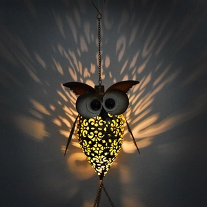 Detailed view of hollow owl solar light casting warm flower patterns on the wall