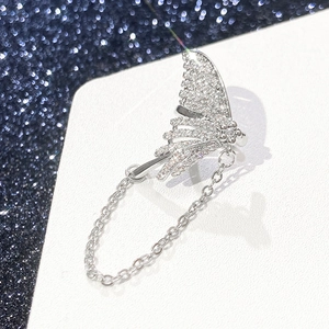 Detailed view of silver butterfly ear cuff with sparkling zircons and dangling metal chain