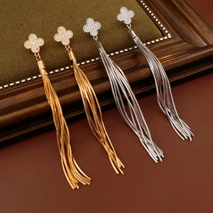 Detail of clover zircon stud earrings with long metal tassels in gold and silver