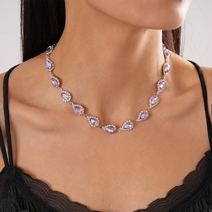 Detailed view of luxury purple waterdrop pendant with diamonds on a female neck