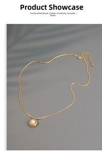 Detailed shot of freshwater pearl pendant necklace with gold wire wrap on dark background