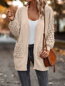 Detail shot of apricot knitted cardigan featuring textured sleeves and functional pockets