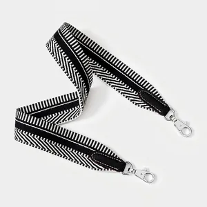 Detail of wide woven shoulder strap featuring black and white herringbone pattern