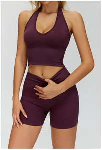 Detail eines dunkelvioletten Yoga-Sets mit Neckholder-Sport-BH und Shorts mit hoher Taille