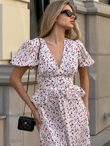 Détail de robe fleurie à col en V avec manches bouffantes et volants à la taille