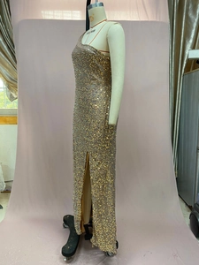 Detail der Pailletten-Schulterpartie und des Schlitzsaums am goldenen Abendkleid