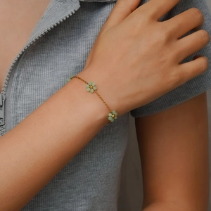 Bohemian beaded flower bracelet with gold chain and light green floral accents